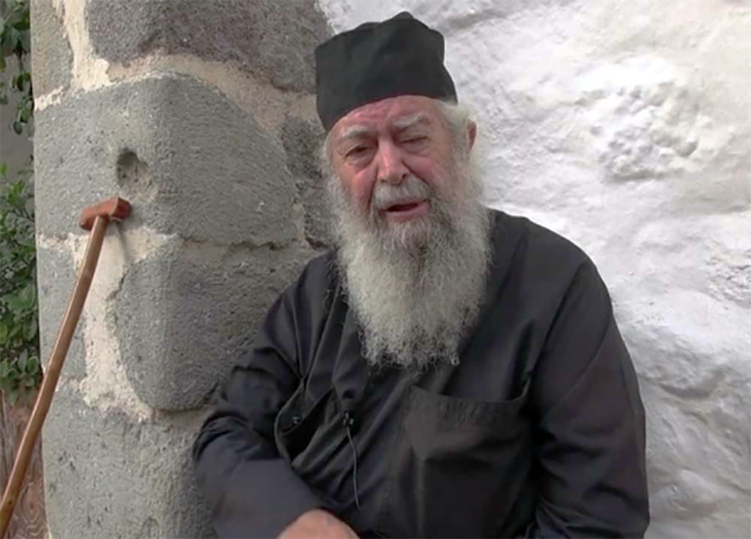 Ο π. Λάζαρος αγιάζει το νερό πριν τις βαπτίσεις.